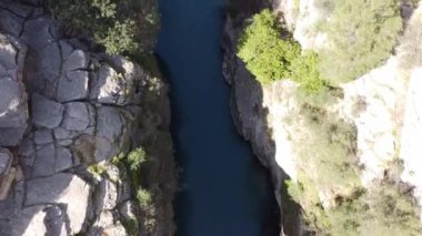 Kayaların arasındaki vadideki dağ nehri, insansız hava aracının havadan çekilmiş fotoğrafı.