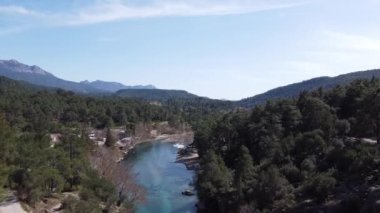 Ormandaki nehir, dağların arka planına karşı ve hava aracından gökyüzü manzarası, hava fotoğrafçılığı.