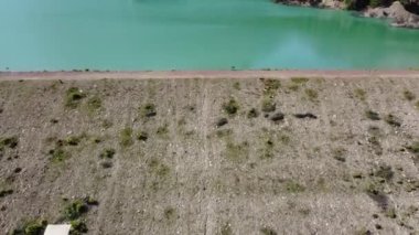 Dağlarda baraj, çam ormanlarının ve taş dağların arka planında mavi göl, hava fotoğrafçılığı.