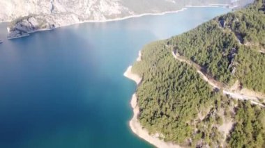 Dağ, dağ nehrinin üzerinde bir yılanla kanyon vadisindeki dağların arka planına karşı, hava fotoğrafçılığı. Yüksek kaliteli FullHD görüntüler