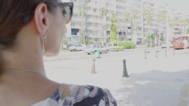 Bir bankta oturan bir kız yüzünden şehirde kırmızı bir tramvay sürüyor. Yüksek kalite 4k görüntü
