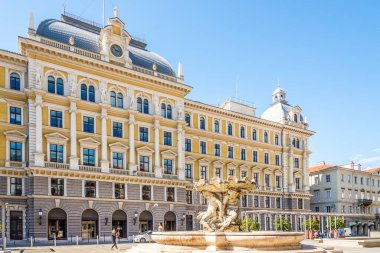 TRIESTE, İtalya - 31 bin 2021 - Trieste 'deki Triton Çeşmesi ile Müze Binası. Trieste, İtalya 'nın kuzeydoğusunda yer alan bir şehirdir..
