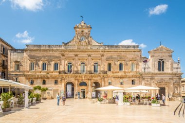 OSTUNI, İtalya - 3 Eylül 2021 - Ostuni 'deki San Fracesco Kilisesi ve belediye binasında görüş. Ostuni, İtalya 'nın Apulia bölgesinde, kıyıdan yaklaşık 8 km uzaklıkta bulunan bir şehir ve komün..