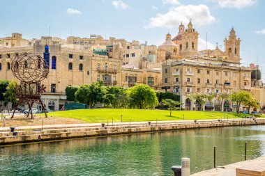 COSPICUA, MALTA - 4 Ekim 2021 - Deniz kanalı ve Cospicua 'daki binalara bakın. Cospicua (Bormla), Malta 'nın güneydoğu bölgesinde yer alan bir liman kentidir..