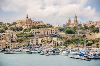 MGARR, MALTA - 5 Ekim 2021 - Mgarr kasabasının limanında kiliseli manzara. Mgarr güneydoğu Gozo, Malta 'da bir liman kasabasıdır..