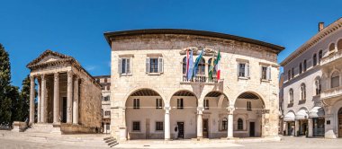 PULA, CROATIA - 25 Nisan 2022 - Augustus Tapınağı ve Pula Belediye Binası manzarası. Pula, Hırvatistan 'ın Istria ilinin en büyük kentidir..