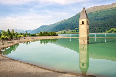 CURON VENOSTA, İtalya - 21 Haziran 2022 - Suyun altındaki eski kasabanın çan kulesiyle Resia Gölü manzarası. Curon Venosta kuzey İtalya 'da Güney Tyrol' da bir komündür..