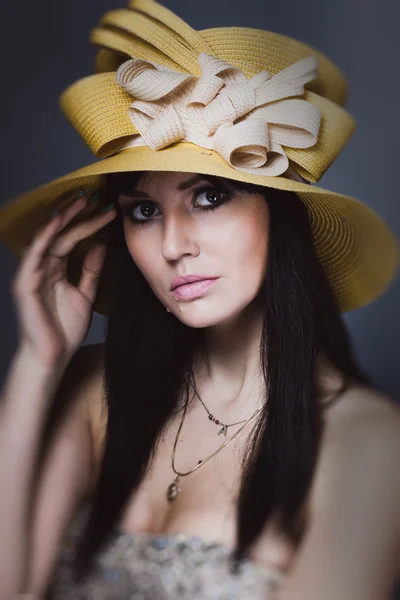 Portret van een mooie brunette meisje in geel hoed — Stockfoto