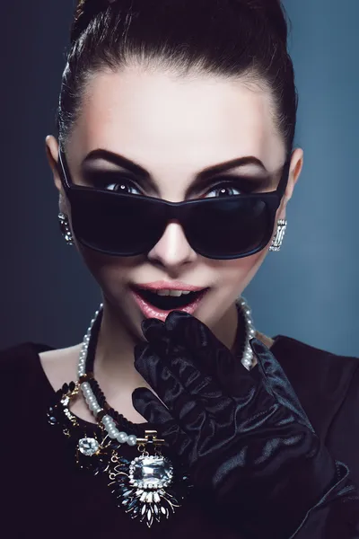 Ritratto giovane ragazza ricca con sorpresa e passerà occhiali bocca dezhit o gioielli sul collo. Studio photo.Lovely donna ritratto retrò . — Foto Stock