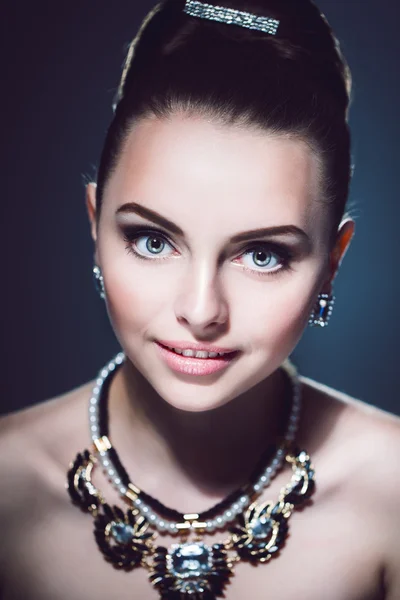 Retrato de una niña sonriente con joyas Sorprendida dama de lujo.Imagen de una niña en retro.Estilo vintage. Foto de moda. Retrato retro de mujer encantadora. Foto de estudio de una mujer joven en estilo retro. . —  Fotos de Stock