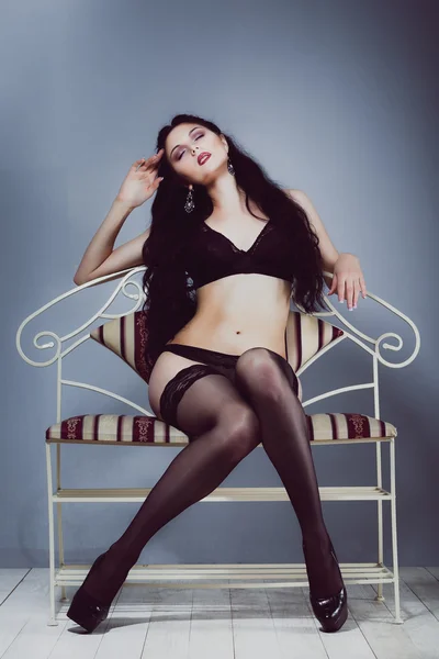 Sexy brunette girl standing in black lingerie and stockings — Stock Photo, Image