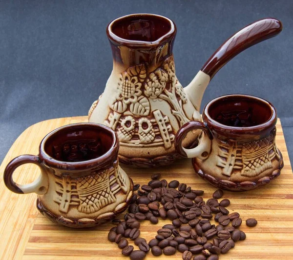 Coffee set and beans on the bamboo cutting board with grey background, selective focus