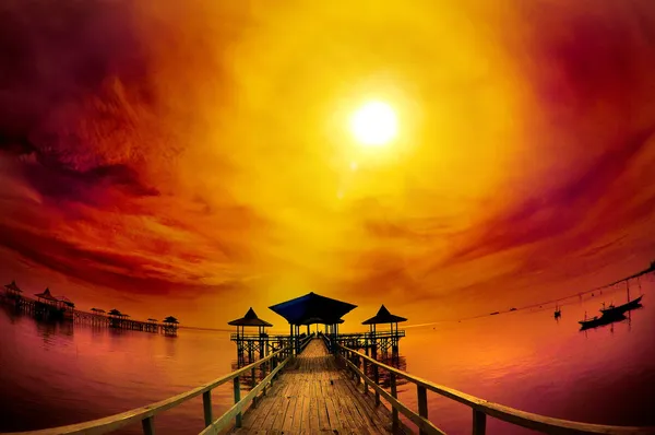 Exotic wooden pier and ocean under cloudy sunrise — Stock Photo, Image