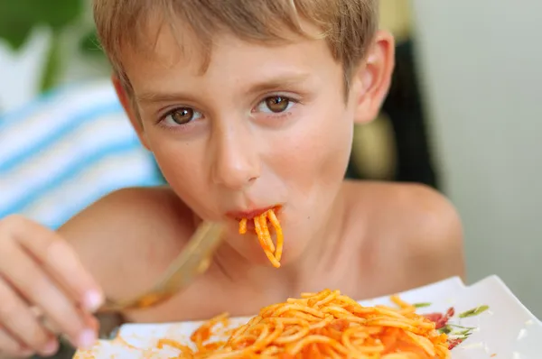 Little boy eating spaghetti