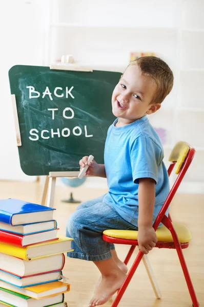 Little schoolboy at the chalkboard