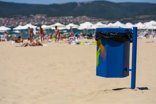 在海滩上涂鸦蓝色垃圾篮. — 图库照片