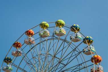 dönme dolap ile farklı renklerde küçük yük arabalar.