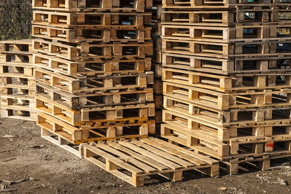 Houten transportpallets in stapels klaar voor levering. — Stockfoto