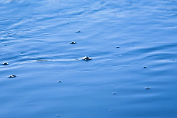 Kék víz felszínén látható levegő buborékok. — Stock Fotó