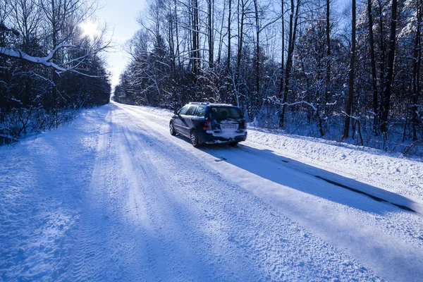 Bil på en farlig sträcka av vägen med snö och is. — Stockfoto