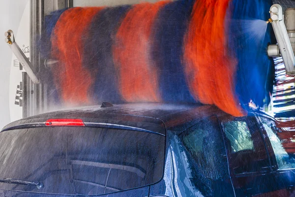 Car wash, in automatic car wash, rotating red and blue brushe. — Stock Photo, Image