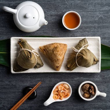 Zongzi. Çin geleneksel Ejderha Tekne Festivali (Duanwu Festivali) için siyah arka plan üzerine pirinç köfteli hamur tatlısı tasarımı konsepti.