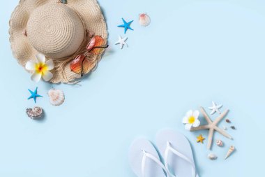 Yaz sahili tasarım konsepti. Deniz kabukları, şapka, mavi arka planda terlik ile tatil seyahatinin en üst görüntüsü.