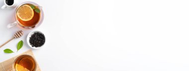 Beyaz masa arkasında sarı limon ve nane yaprağı olan ballı siyah çay konseptini tasarla.