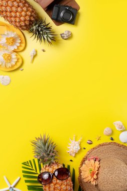 Yaz meyvesi tasarımı konsepti. Deniz kabukları, ananas ve sarı arka planda palmiye yaprakları olan tatil gezilerinin en iyi manzarası..