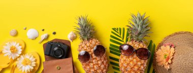 Yaz meyvesi tasarımı konsepti. Deniz kabukları, ananas ve sarı arka planda palmiye yaprakları olan tatil gezilerinin en iyi manzarası..