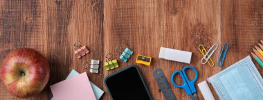 Öğrenci tasarım konseptine geri dön, ahşap masa arkaplanının üzerinde fotokopi alanı ile kırtasiye malzemesi üst görünümü.