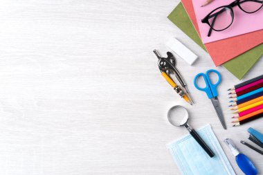 Öğrenci tasarım konseptine geri dön, ahşap masa arkaplanının üzerinde fotokopi alanı ile kırtasiye malzemesi üst görünümü.