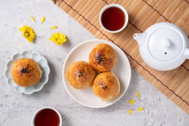 Ay pastası sarısı konsepti, Sonbahar Festivali ortası için ay çöreği koyu gri masa arkaplanında tatil