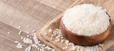 Çiğ beyaz cilalanmış yenilebilir pirinç ahşap masa arkasında, organik tasarım konsepti..