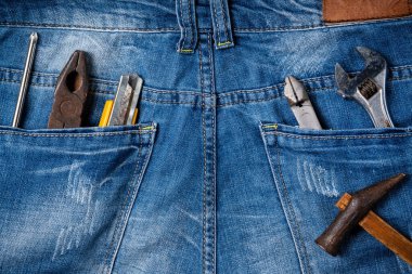 Mavi kot pantolon arka planında çalışma araçlarıyla İşçi Bayramı 'nın üst görünüm tasarım kavramı.