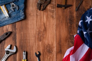Çalışma araçları ve ahşap masa üzerinde kot pantolon ile İşçi Bayramı 'nın üst görünüm tasarım konsepti.