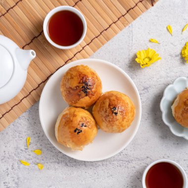 Ay pastası sarısı konsepti, Sonbahar Festivali ortası için ay çöreği koyu gri masa arkaplanında tatil