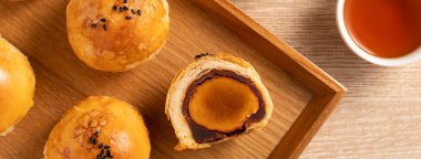 Top view tasarım konsepti: Ay pastası sarısı pastası, Sonbahar Festivali için ay çöreği, ahşap masa arkasında tatil.