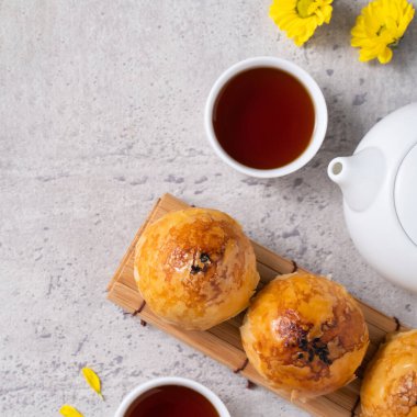 Ay pastası sarısı konsepti, Sonbahar Festivali ortası için ay çöreği koyu gri masa arkaplanında tatil