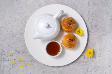 Ay pastası sarısı konsepti, Sonbahar Festivali ortası için ay çöreği koyu gri masa arkaplanında tatil