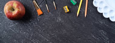 Okul öğrencilerinin tasarım konseptine geri dön, sayfa siyah masa arkaplanının üstündeki kırtasiyeye fotokopi alanı ile üst görünüm.