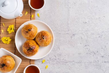 Ay pastası sarısı konsepti, Sonbahar Festivali ortası için ay çöreği koyu gri masa arkaplanında tatil