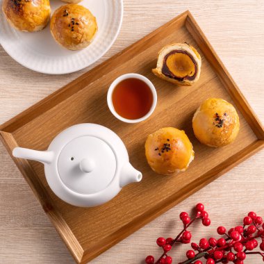 Top view tasarım konsepti: Ay pastası sarısı pastası, Sonbahar Festivali için ay çöreği, ahşap masa arkasında tatil.