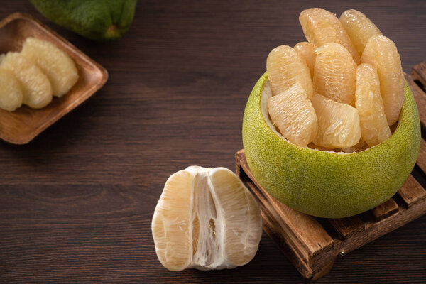 Close up of fresh peeled pomelo on wooden table background for Mid-Autumn Festival fruit.