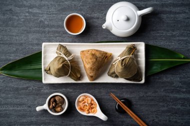 Zongzi. Çin geleneksel Ejderha Tekne Festivali (Duanwu Festivali) için siyah arka plan üzerine pirinç köfteli hamur tatlısı tasarımı konsepti.