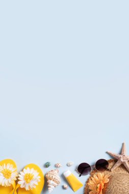Yaz sahili tasarım konsepti. Deniz kabukları, şapka, mavi arka planda terlik ile tatil seyahatinin en üst görüntüsü.