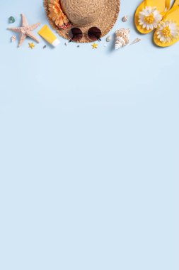 Yaz sahili tasarım konsepti. Deniz kabukları, şapka, mavi arka planda terlik ile tatil seyahatinin en üst görüntüsü.