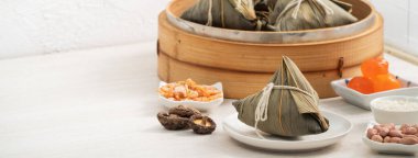 Zongzi. Geleneksel Çin Ejderha Tekne Festivali (Duanwu Festivali) için pirinç köftesi pencere önü açık ahşap masa arkaplanı üzerine.