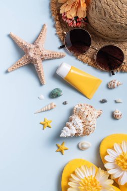Yaz sahili tasarım konsepti. Deniz kabukları, şapka, mavi arka planda terlik ile tatil seyahatinin en üst görüntüsü.