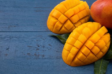 Mavi masa arkaplanının üzerinde dilimlenmiş parçalar olan güzel tropikal meyve tasarımı konsepti.